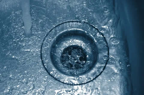 Technician performing drain cleaning in a Manteca, CA kitchen